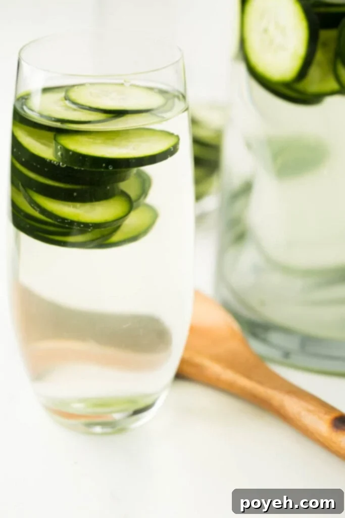 Effortless Cucumber Water for Ultimate Refreshment 2 closeup image of cucumber infused water with ice and fresh cucumber slices