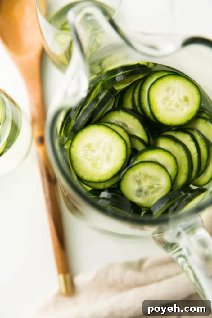 Effortless Cucumber Water for Ultimate Refreshment 4 overhead shot of cucumbers in glass water pitcher ready to be served