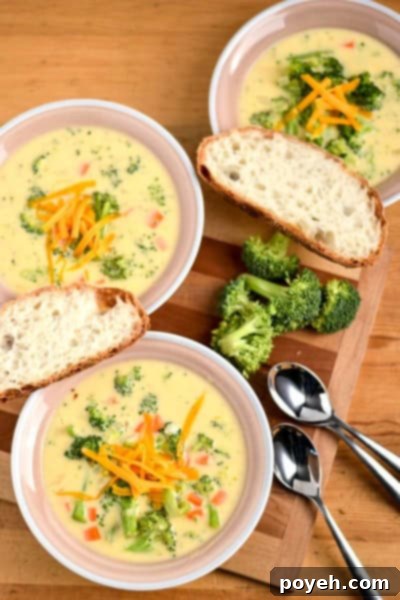 A cozy bowl of rich and creamy cheddar broccoli soup, generously filled with tender broccoli florets and melted cheese, perfect for a comforting meal.