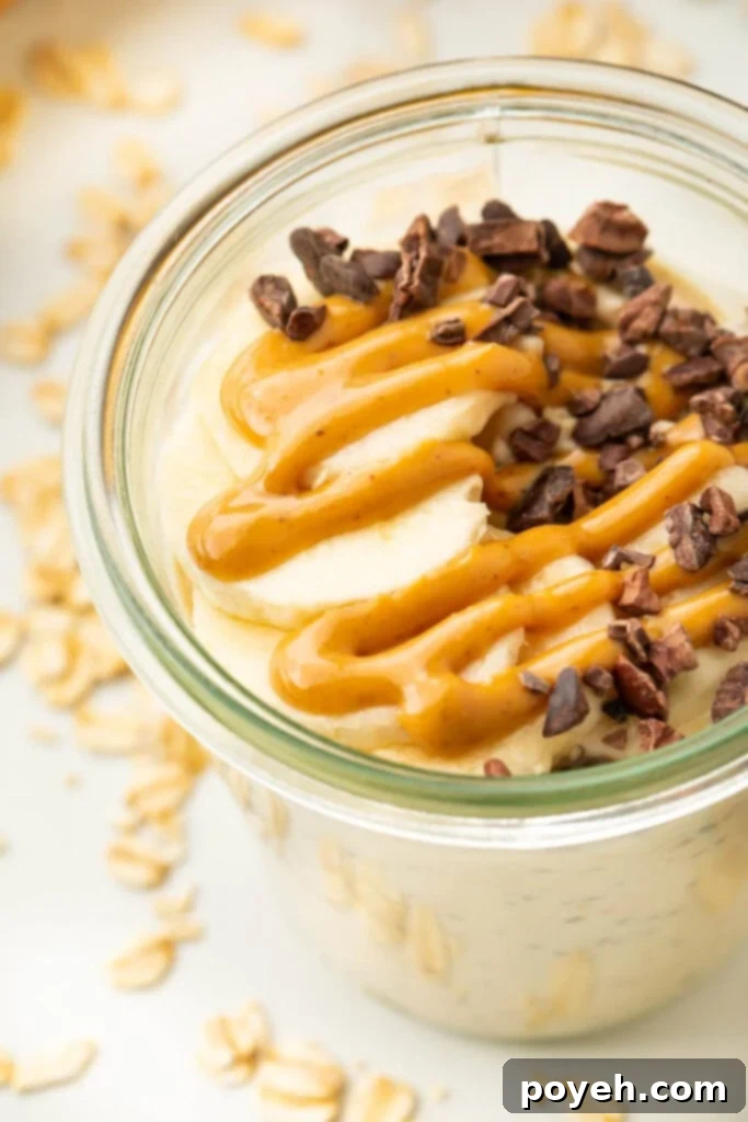 Mason jar with creamy peanut butter overnight oats, topped with banana slices and a drizzle of melted peanut butter.