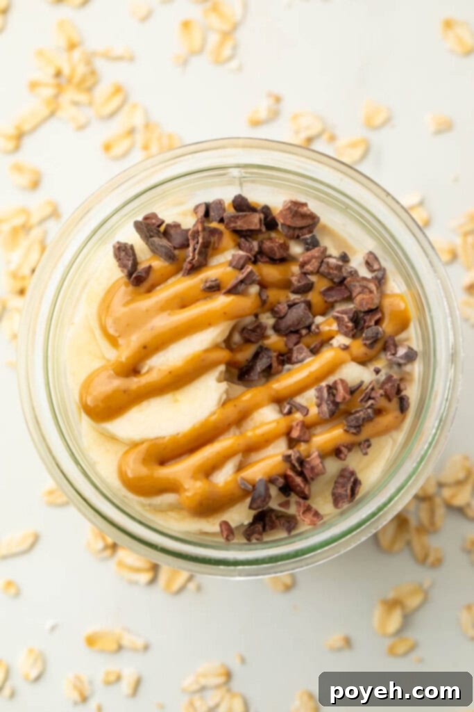 Two mason jars with peanut butter overnight oats, topped with various delicious additions.