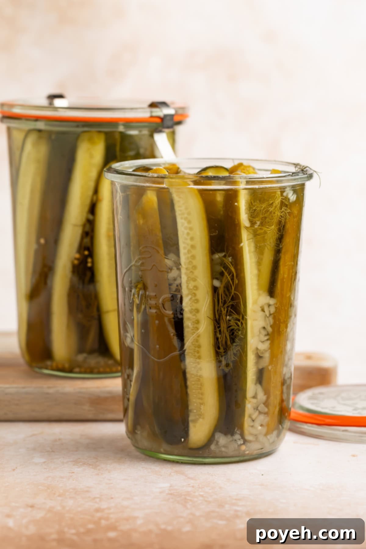 Open jar of homemade pickles with another sealed jar in the background.