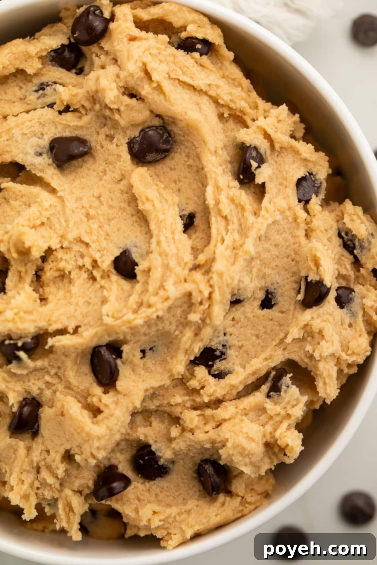 A large, inviting bowl brimming with freshly made vegan cookie dough, showcasing its smooth texture and readiness for enjoyment.