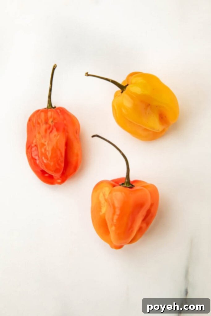 Close-up shot of fresh, vibrant habanero peppers on a cutting board, ready to be prepared for the sauce. Perfect for showing the key spicy ingredient.