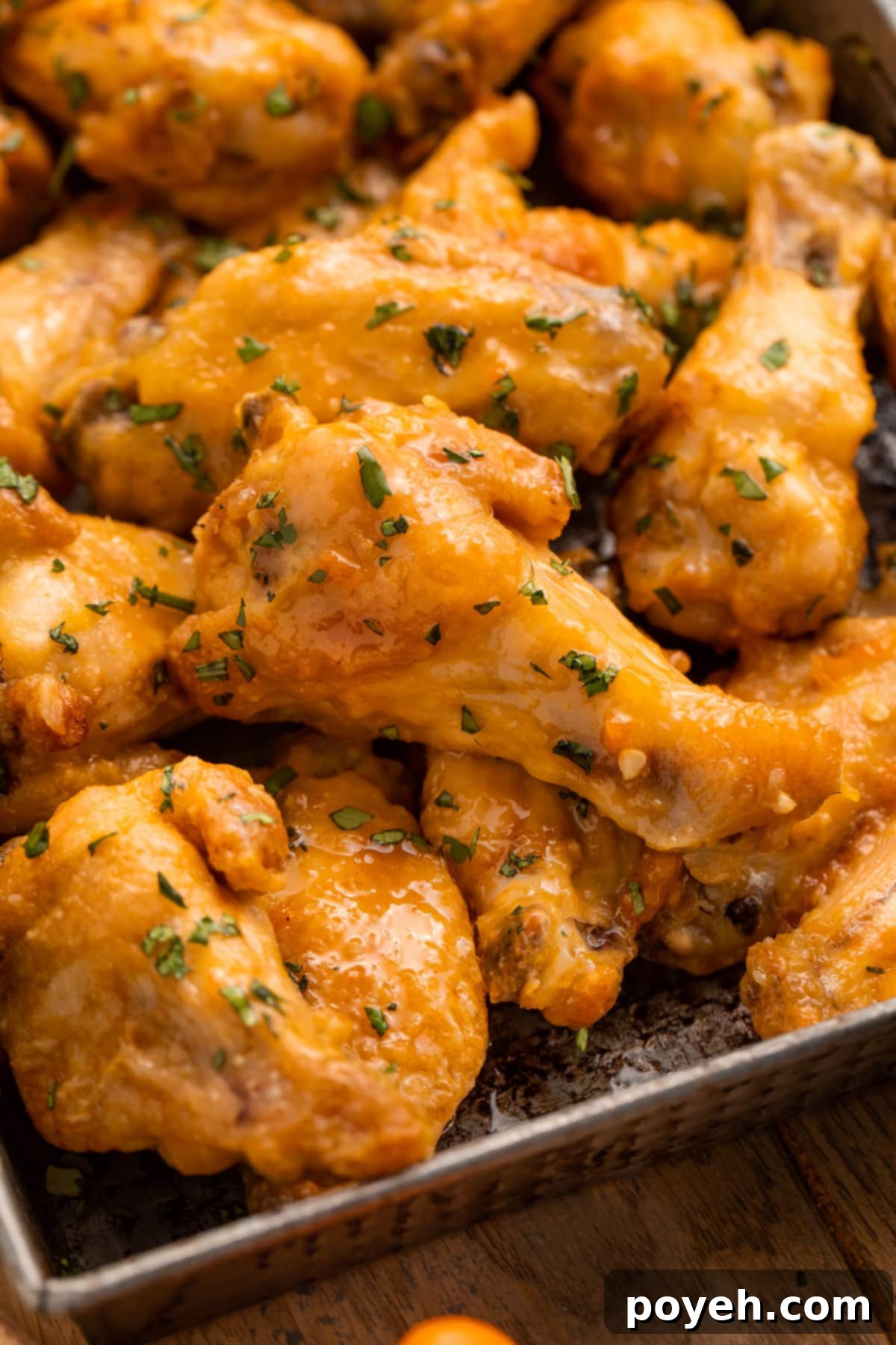 A pan of juicy chicken wings in an orange mango habanero sauce, ready to be served.