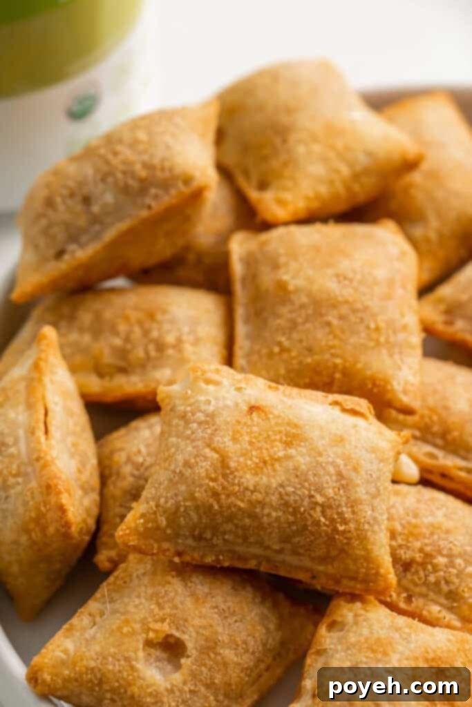 Crispy Air Fryer Pizza Rolls piled on a plate, ready to be served with a side of dipping sauce