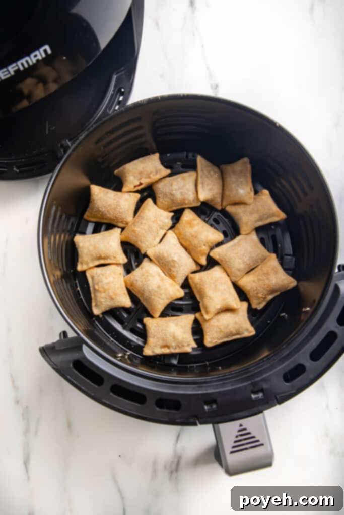 Close-up view of perfectly cooked pizza rolls arranged neatly in an air fryer basket before serving
