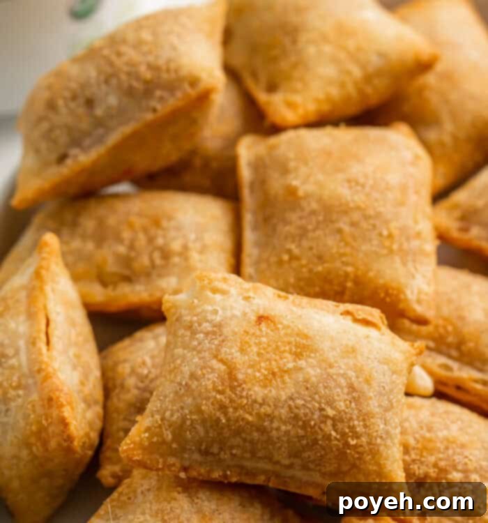 Air fryer pizza rolls, golden and crispy, on a cutting board with dipping sauce