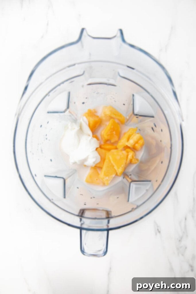 Ingredients for mango pineapple smoothie in a blender before blending