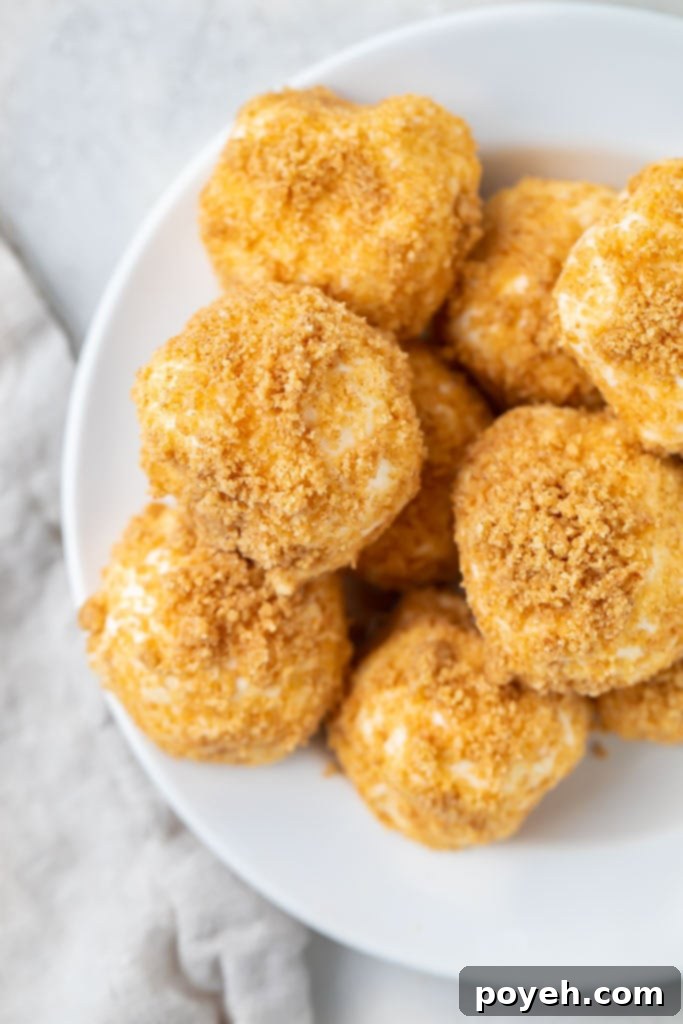 A close-up shot of a delectable mountain of cream cheese fat bombs piled high on a pristine white plate, ready for serving.
