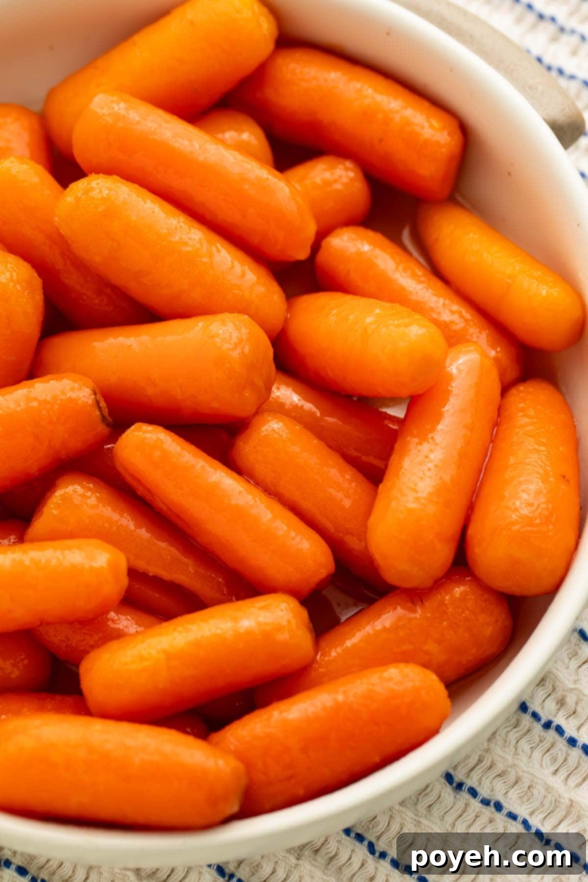 A white bowl holding buttery carrots cooked in the Instant Pot.