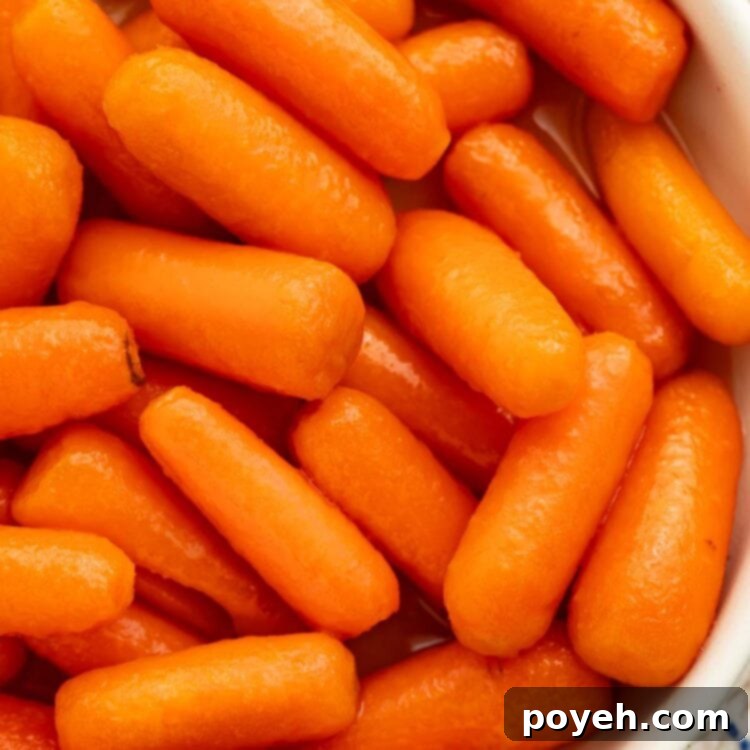 A white bowl holding buttery carrots cooked in the Instant Pot.