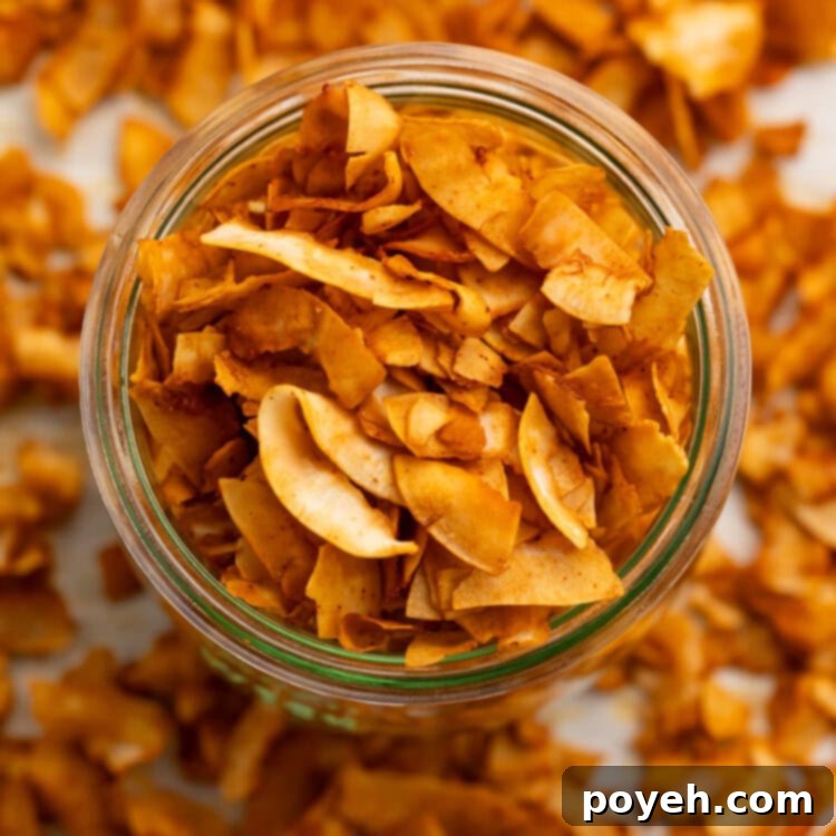 A glass jar filled with golden-brown, crispy coconut bacon on a table, ready to be enjoyed.