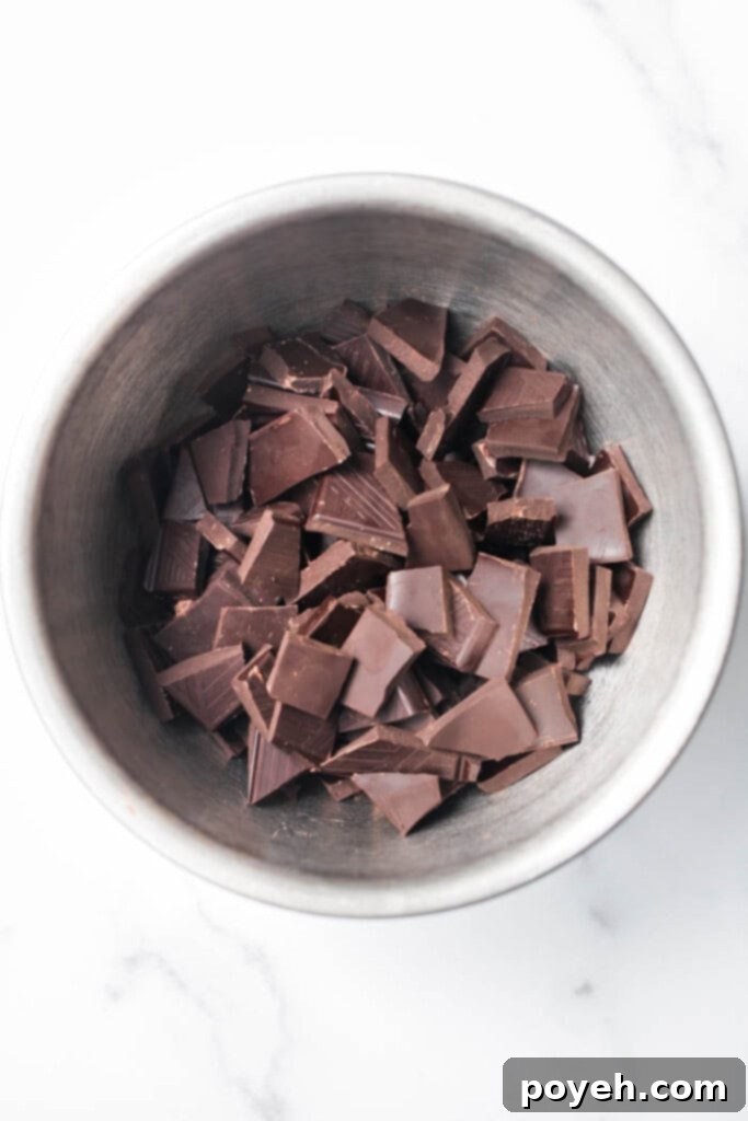 Decadent Chocolate Almonds 3 Close-up of chocolate covered almonds being placed on parchment paper.