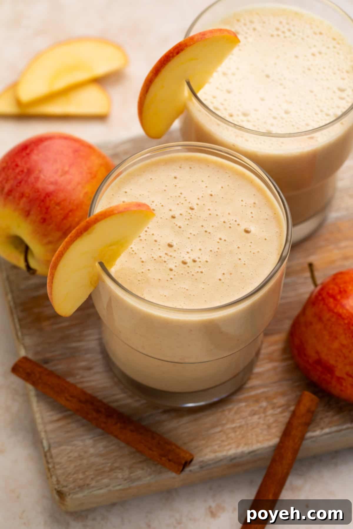 Overhead view of a pair of smoothies garnished with fresh apple.