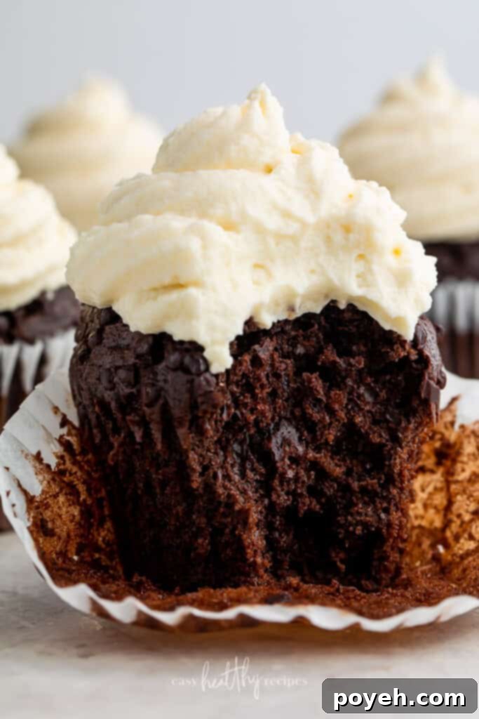 A chocolate keto cupcake with a bite taken out, showcasing the delightful keto cream cheese icing.
