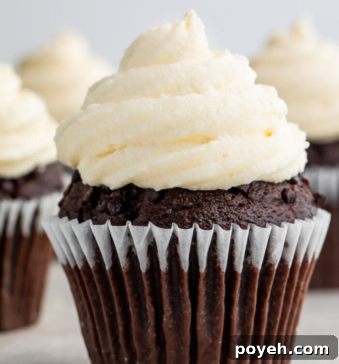 A chocolate cupcake with keto cream cheese icing, highlighting the smooth texture and appealing presentation.