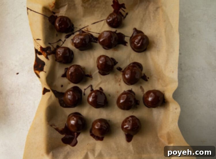 Finished keto truffles with various toppings setting on parchment paper.