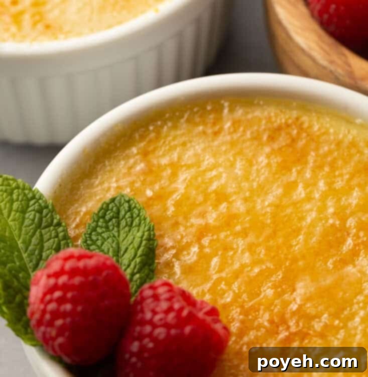Vegan creme brulee in a white ramekin with a raspberry garnish