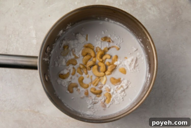 Raw cashews, coconut milk, and arrowroot powder simmering in a small saucepan for the vegan crème brûlée base.