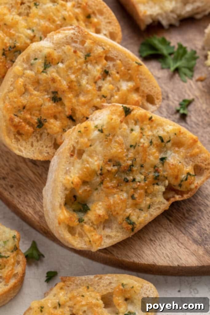 Slices of air fryer garlic bread arranged on a wooden cutting board