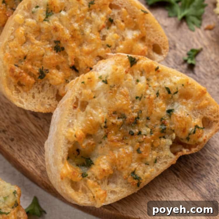 Slices of air fryer garlic bread arranged on a wooden cutting board