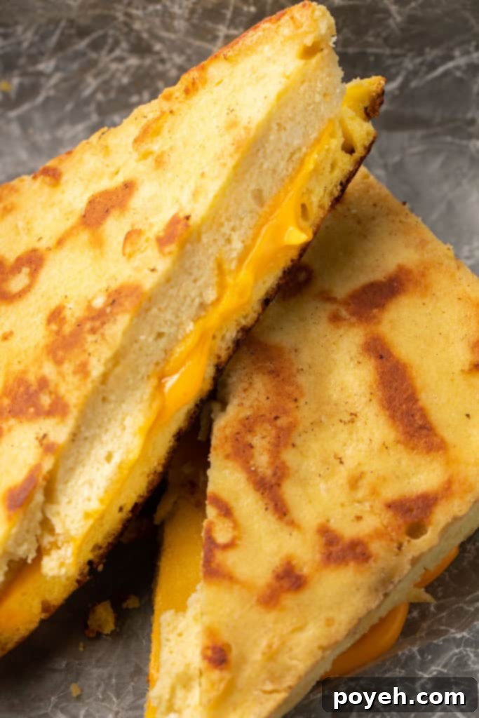 Two halves of keto grilled cheese stacked on top of each other, showcasing the thick bread and melted cheese