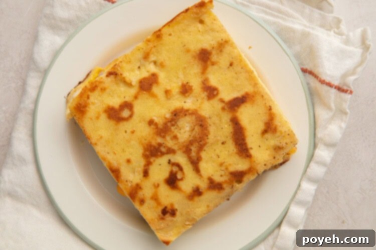 Keto grilled cheese on a white plate, cut in half