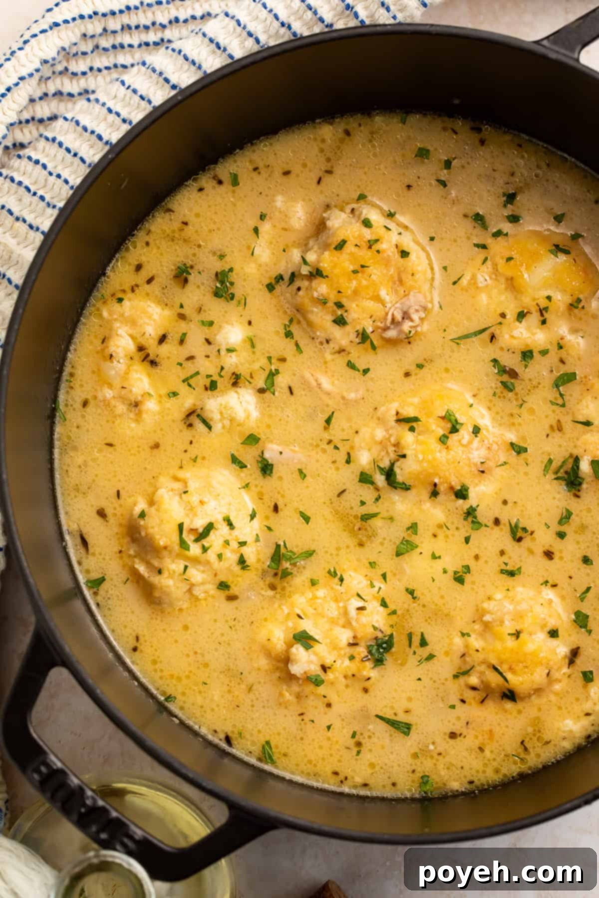 Close up of keto chicken and dumplings in a dutch oven, sprinkled with finely chopped parsley.