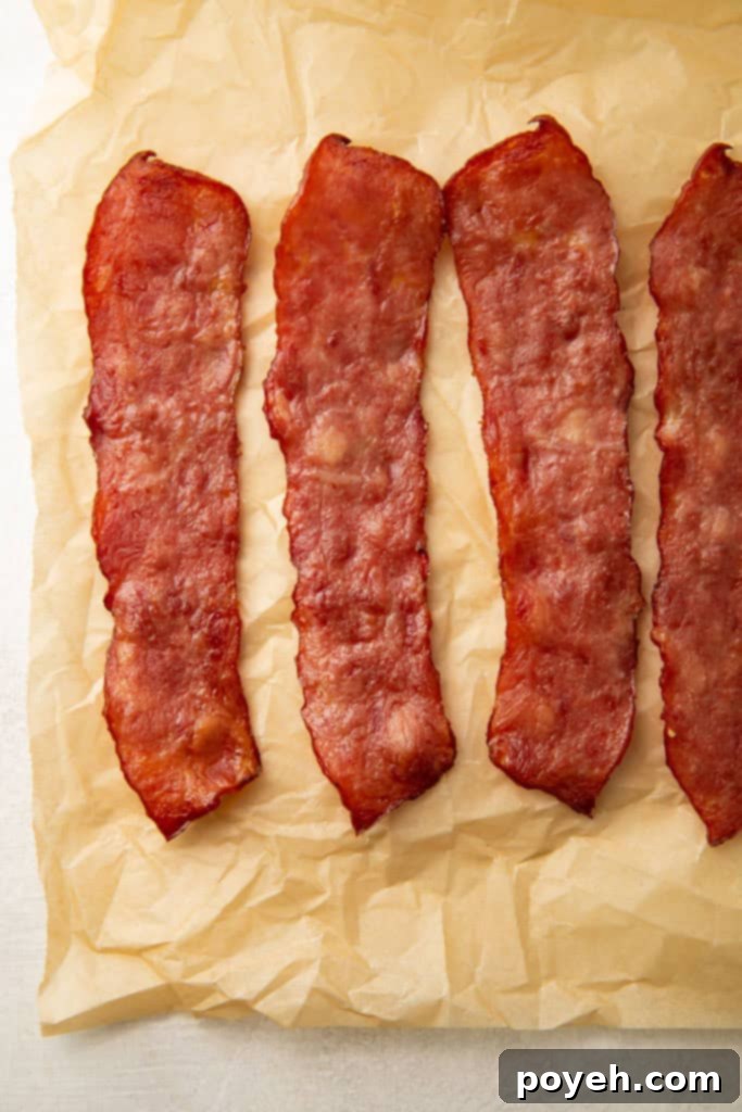 3 and a half slices of turkey bacon on a sheet of parchment paper