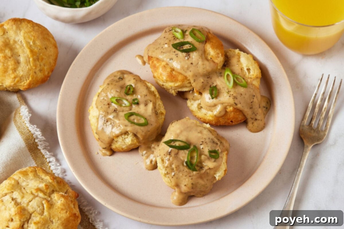 Vegan biscuits and gravy topped with sliced green onions on a plate.