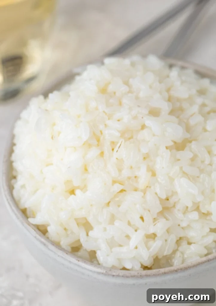White sushi rice in a small silver bowl, taken from the side, showcasing its perfect texture