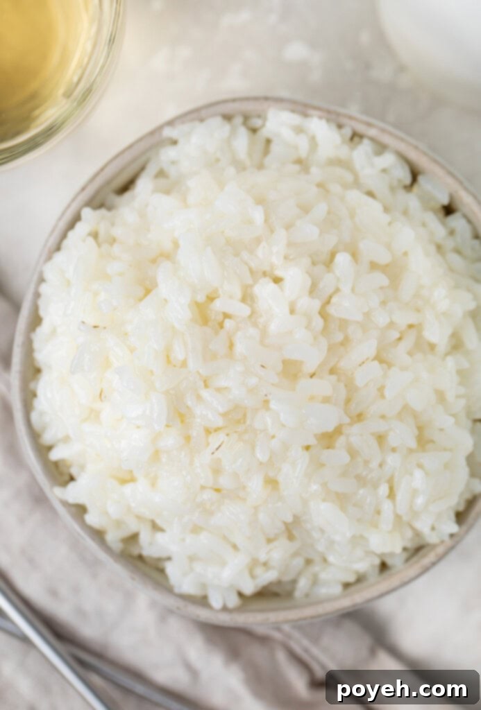Overhead photo of white sushi rice in a small silver bowl, highlighting its perfect texture and presentation