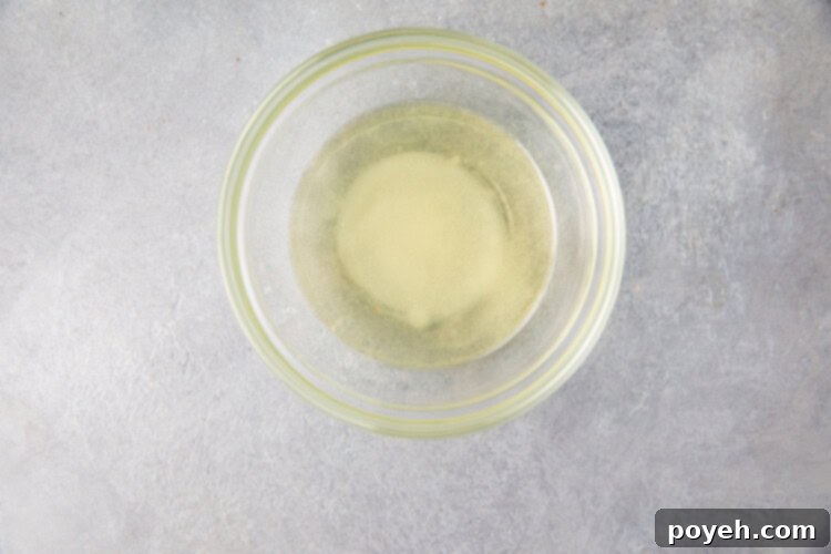 Rice vinegar, salt, white sugar, and oil in a small glass bowl for Instant Pot sushi rice