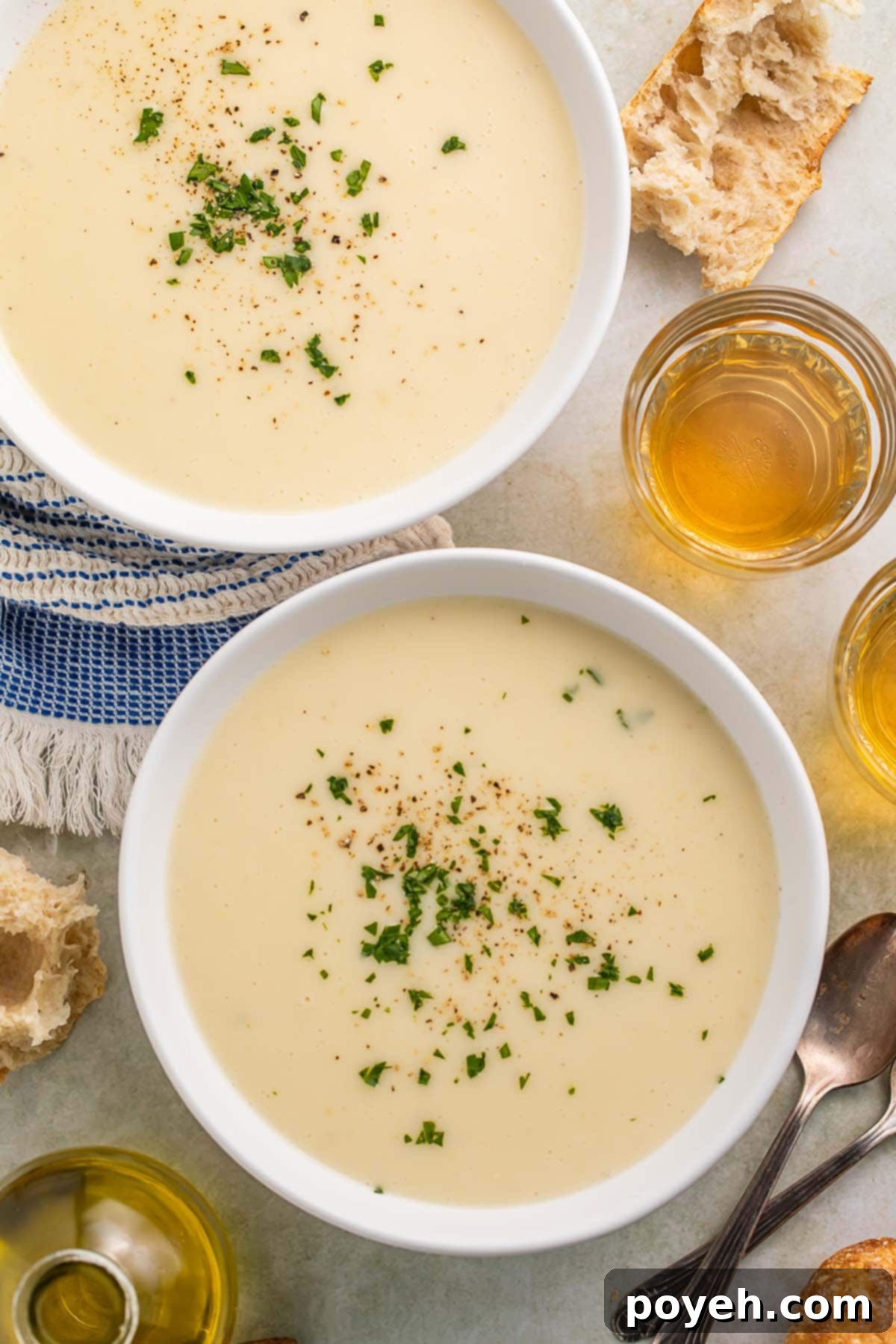 Two bowls of creamy Irish potato soup on a table, garnished and ready to eat.