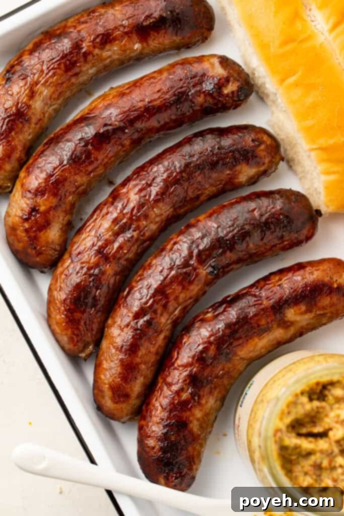 Five perfectly cooked Italian sausages on a platter, ready to serve.