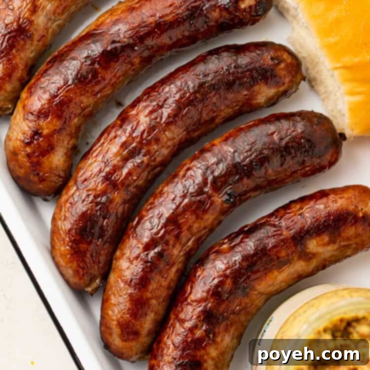 Five cooked Italian sausages on a platter, garnished with fresh herbs.
