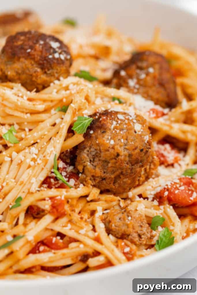 Close up image of keto spaghetti and meatballs with parmesan cheese and parsley on top.