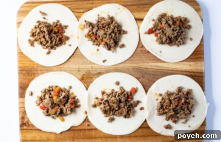 Unfolded empanadas on a cutting board