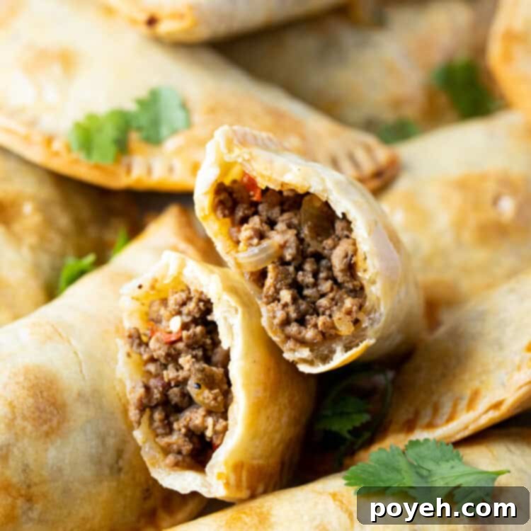 Air fryer empanadas torn in half to show ground beef inside