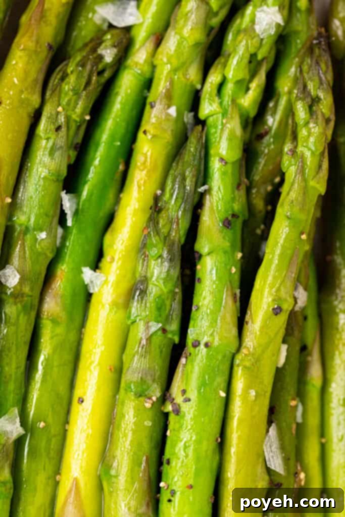 Close up image of perfectly cooked Instant Pot asparagus spears, glistening with butter and lemon, ready to be served.