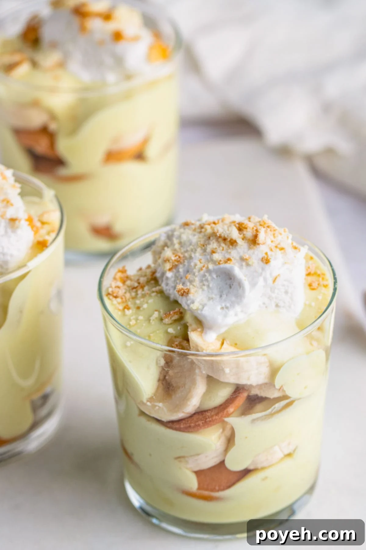 Angled view of a small glass of vegan banana pudding with banana slices and Nilla wafers.