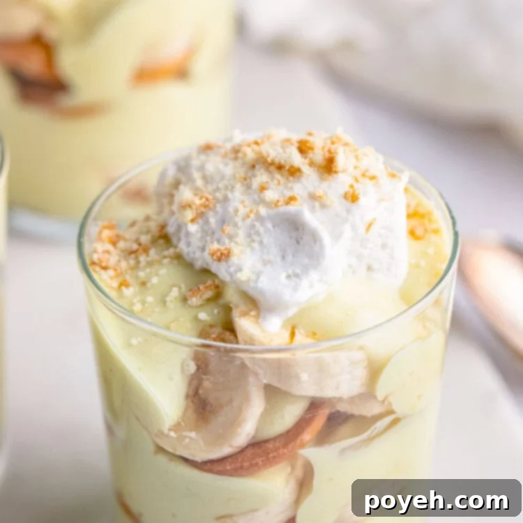 Angled view of a small glass of vegan banana pudding with banana slices and Nilla wafers.