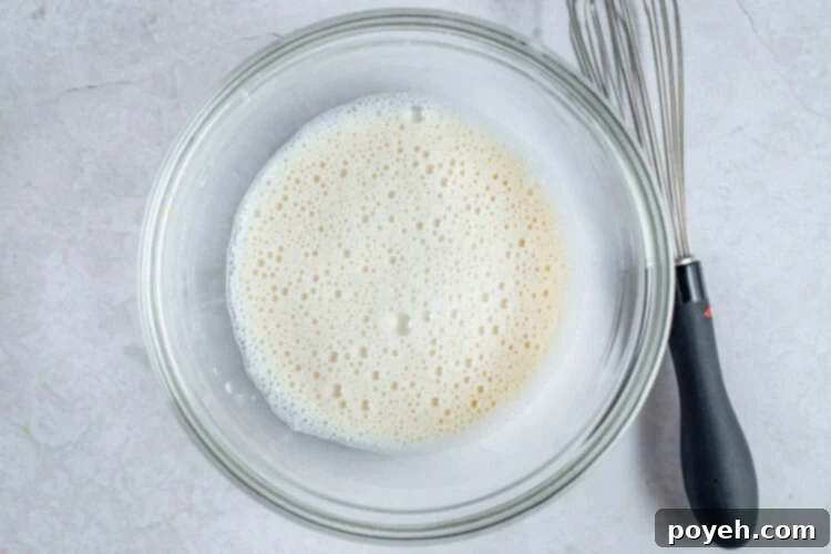 Almond milk and cornstarch in glass mixing bowl.