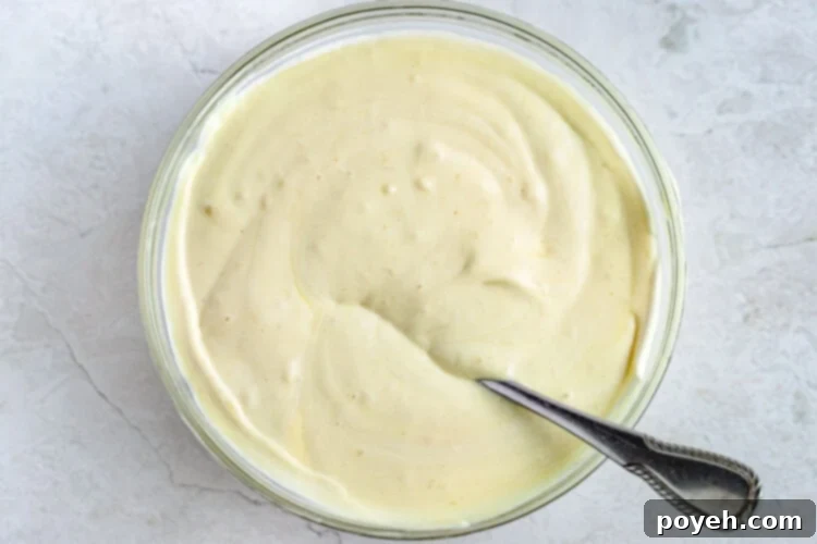Vegan banana pudding in a large glass mixing bowl with a spoon.