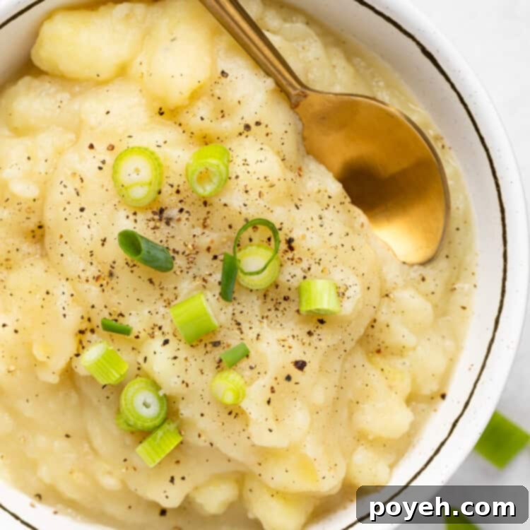 Close-up of freshly made stewed potatoes in a serving bowl, garnished with herbs.