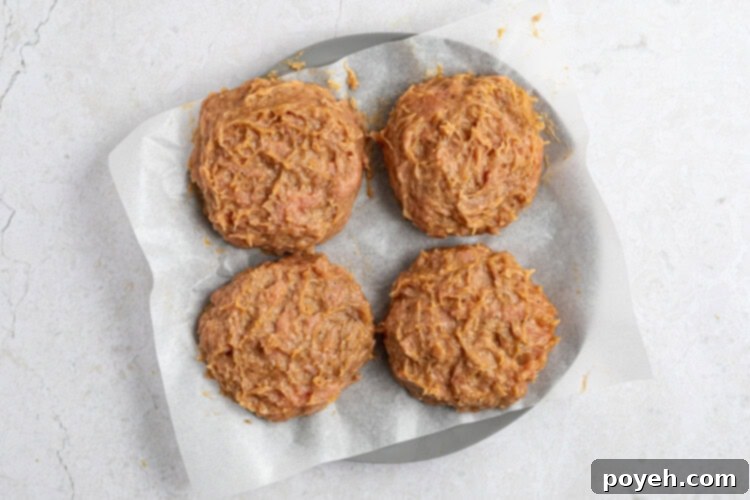 All ingredients for turkey burgers are mixed in a large bowl and shaped into four patties, chilling in the freezer.