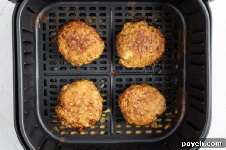 Air fryer basket with turkey burger patties cooking at 360° Fahrenheit.