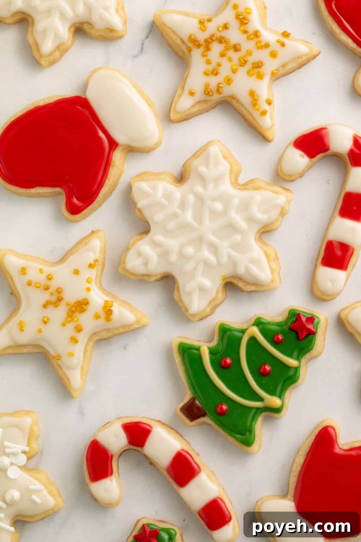Christmas cookies decorated as a star, a snowflake, a tree, candy canes, gloves and a pair of mittens.