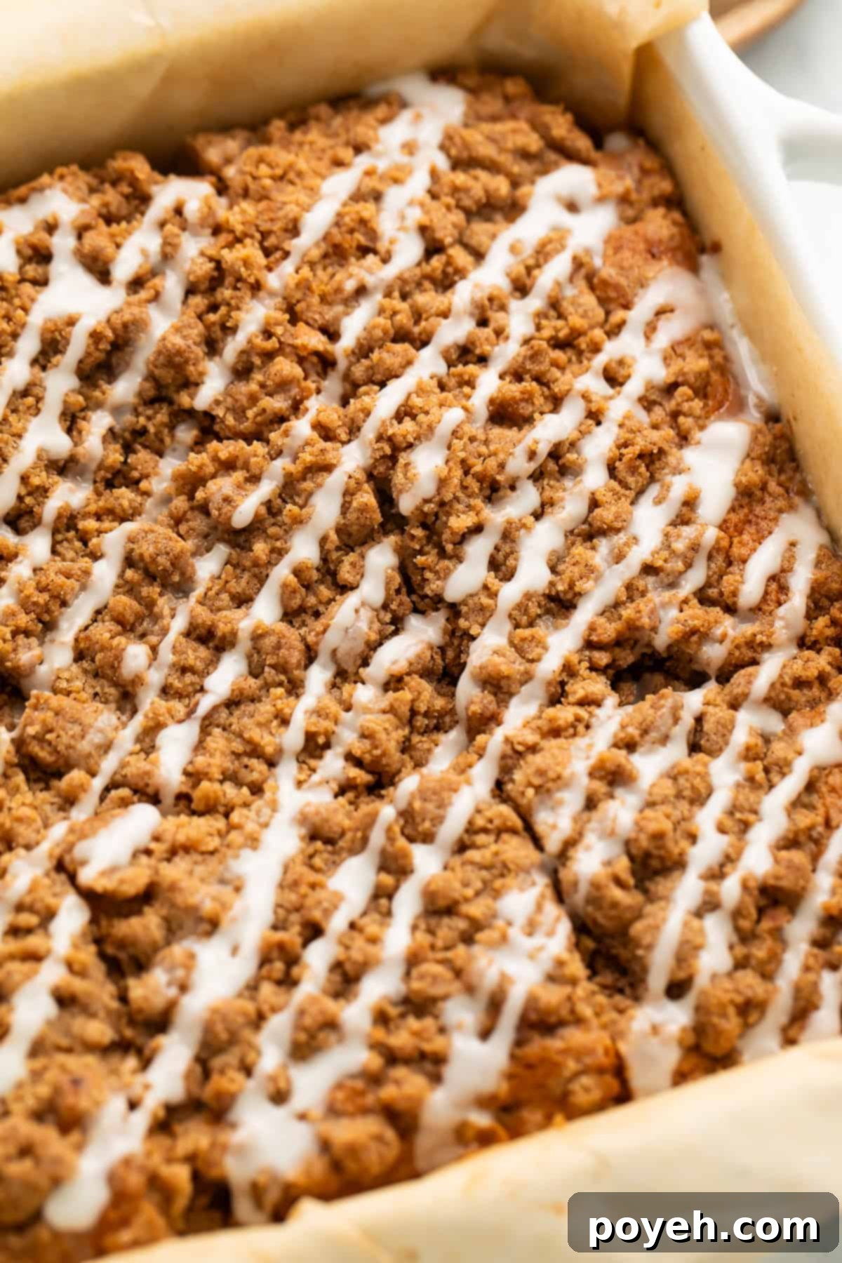 Gluten-free coffee cake with streusel topping and icing drizzle, cut into squares.